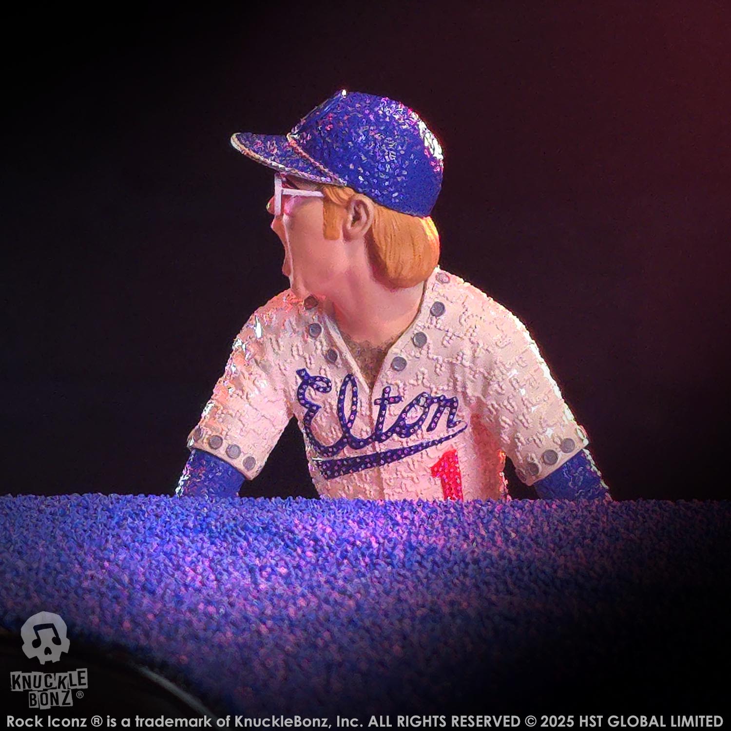 Elton John statue wearing a sequined 'Elton' jersey and cap on a dark background